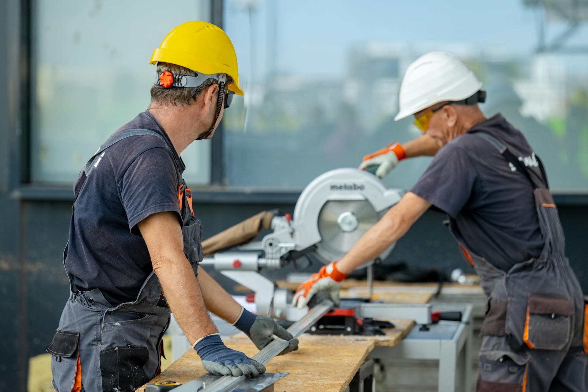 Construction workers using a mitre saw on site